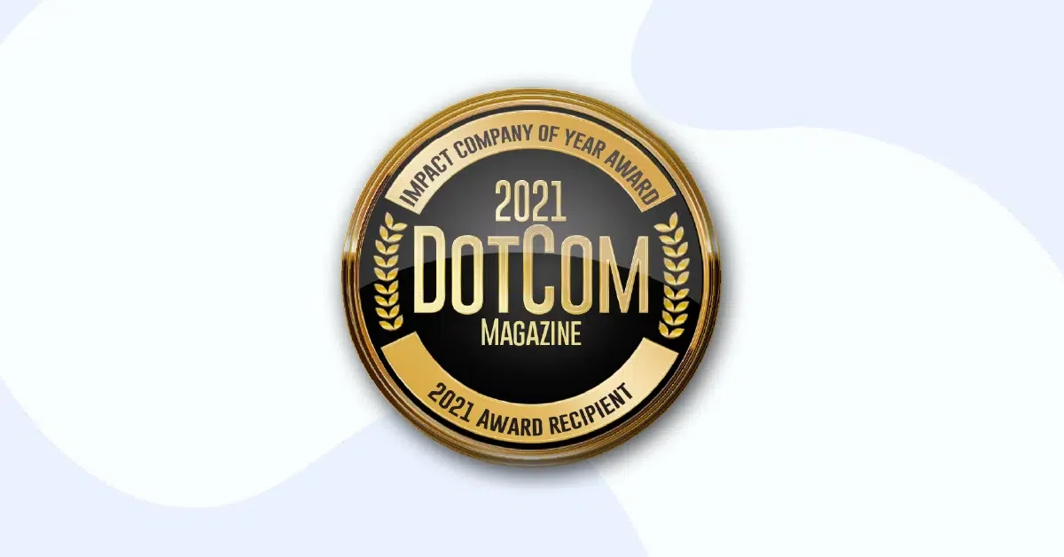 A circular gold and black badge with "DotCom Magazine" in the center. The badge reads "Impact Company of the Year Award" at the top and "2021 Award Recipient" at the bottom. Two gold laurel branches flank the central text, creating a symmetrical, prestigious design.