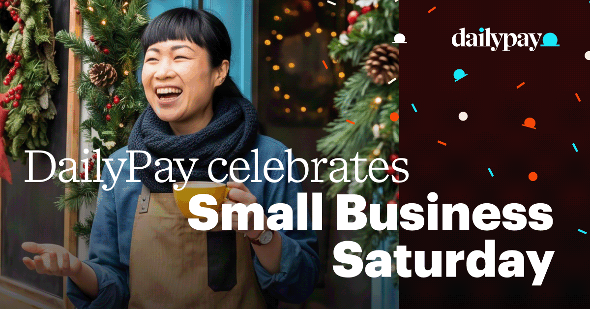 A smiling person holding a mug in front of a holiday-decorated doorway, with text reading “DailyPay celebrates Small Business Saturday.”