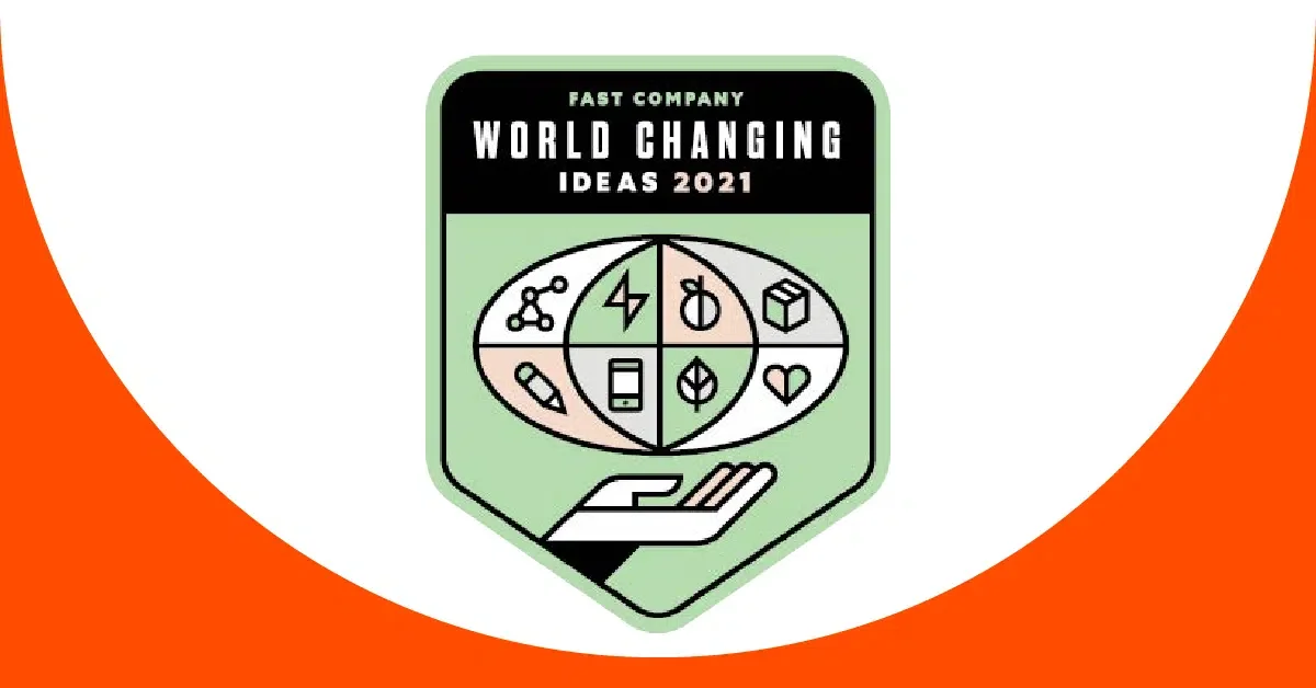 A graphic shows a badge with the title "Fast Company World Changing Ideas 2021." Inside the badge are six icons depicting a molecule, a lightning bolt, a circular arrow, a flask, a pill, and a heart. Below the icons, a stylized hand supports the globe-like arrangement of symbols, with a background of green.